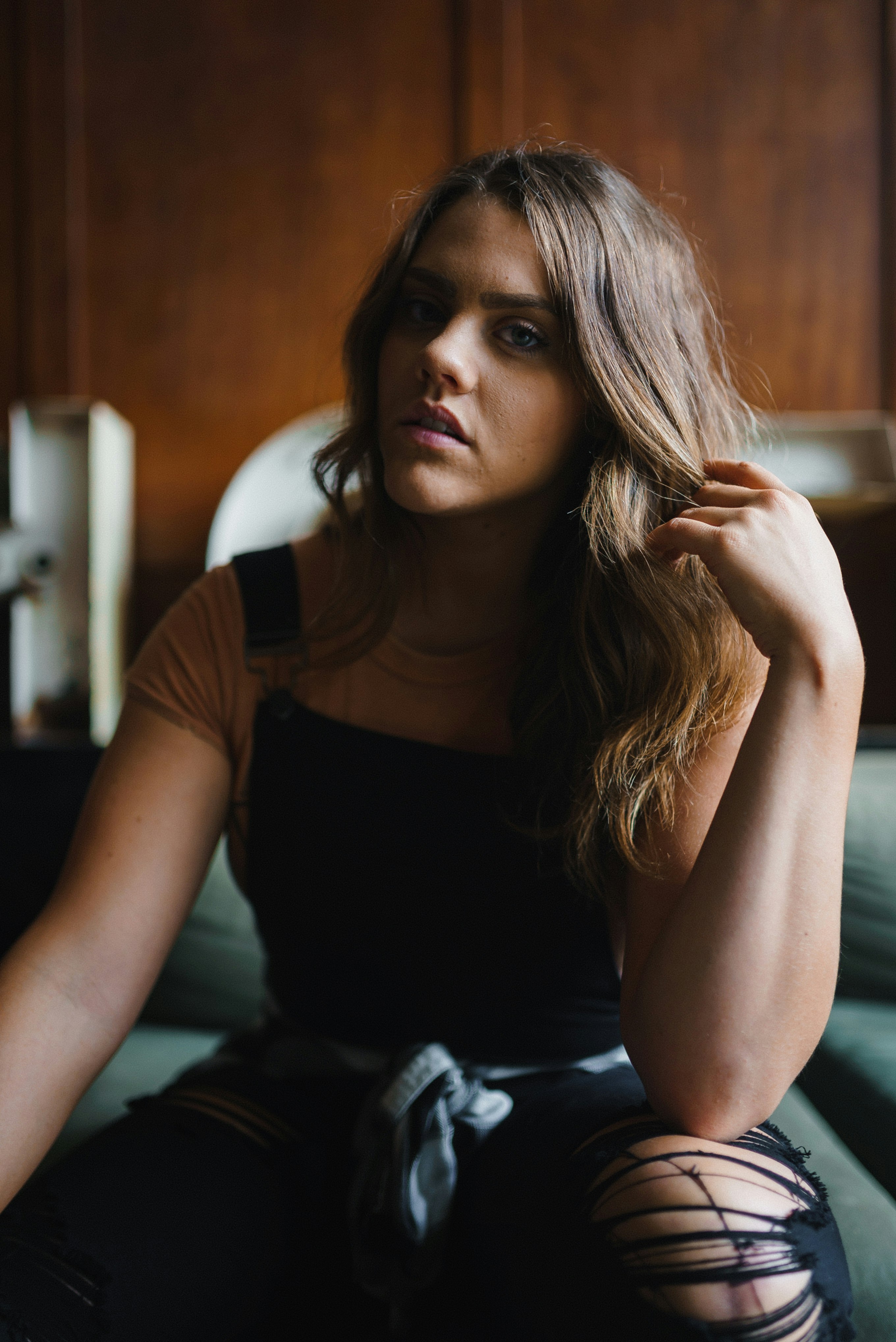 woman in black tank top and black and white shorts sitting on bed